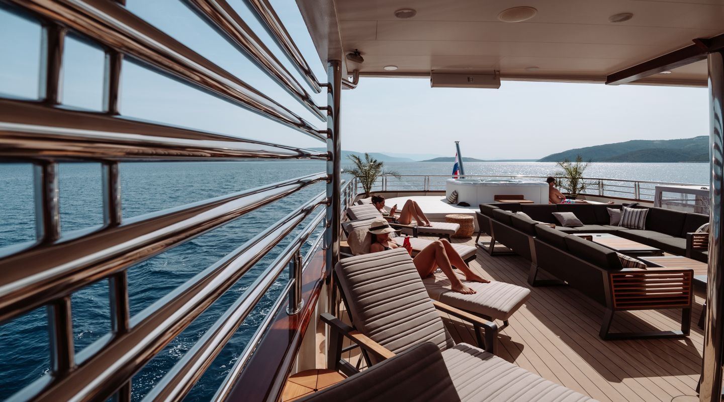 people relaxing on the sun loungers on the yacht deck