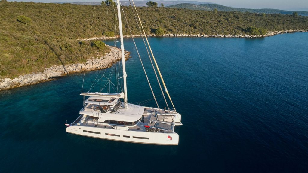 adriatic dragon catamaran yacht anchored by a land