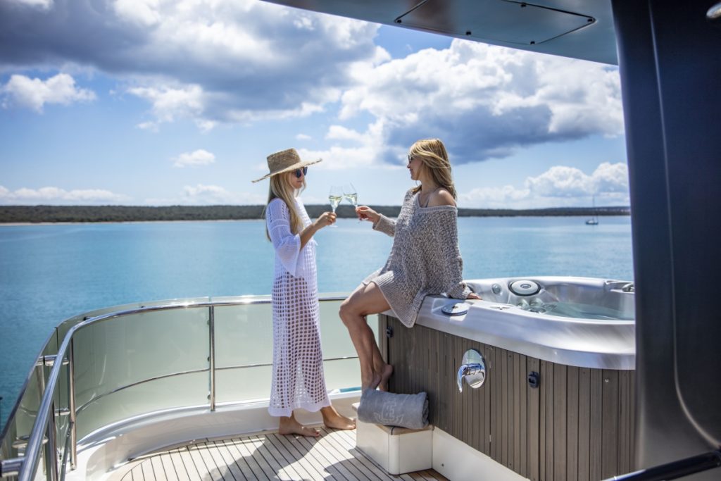 ena yacht charter guests toasting by the jacuzzi