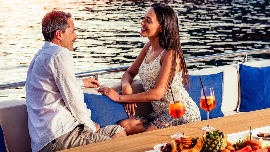 grace yacht charter couple relaxing on the aft deck sofa