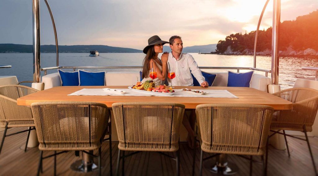couple by the yacht table on a main deck
