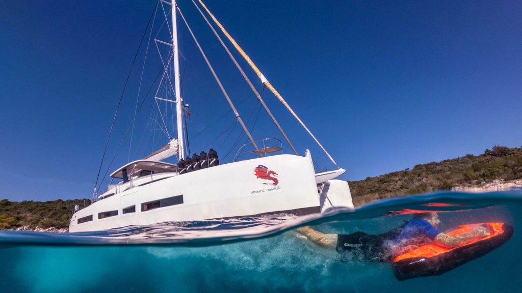 man is playing with a sea bob by lagoon 77 adriatic dragon catamaran yacht