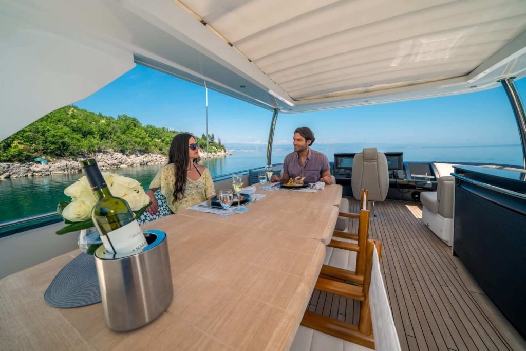 couple is sitting around alfresco main deck yacht table