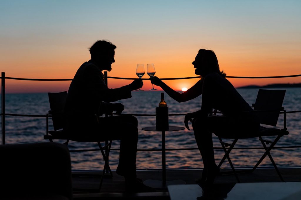 couple on the yacht drinking in a sunset