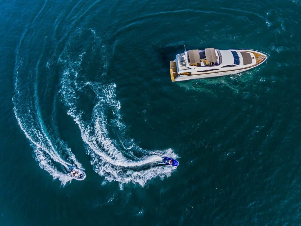 boat and a jet ski cruising around a superyacht quo vadis