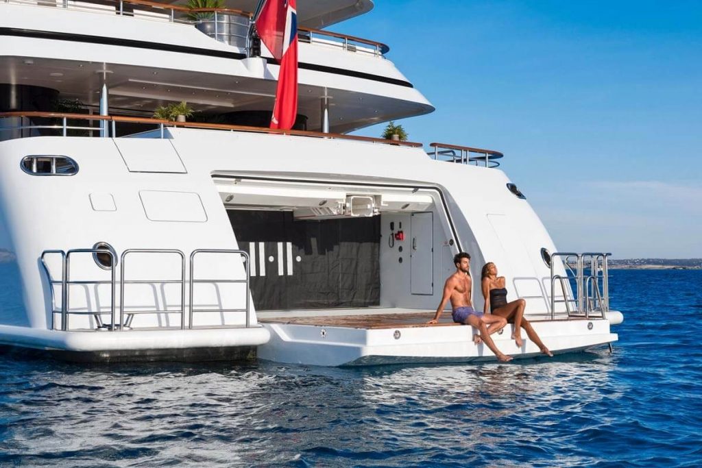 couple is taking a sunbath on a swimming yacht platform
