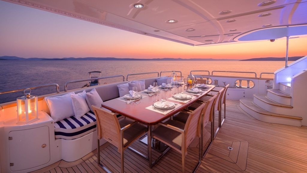 artemy yacht charter al fresco dining table at sunset
