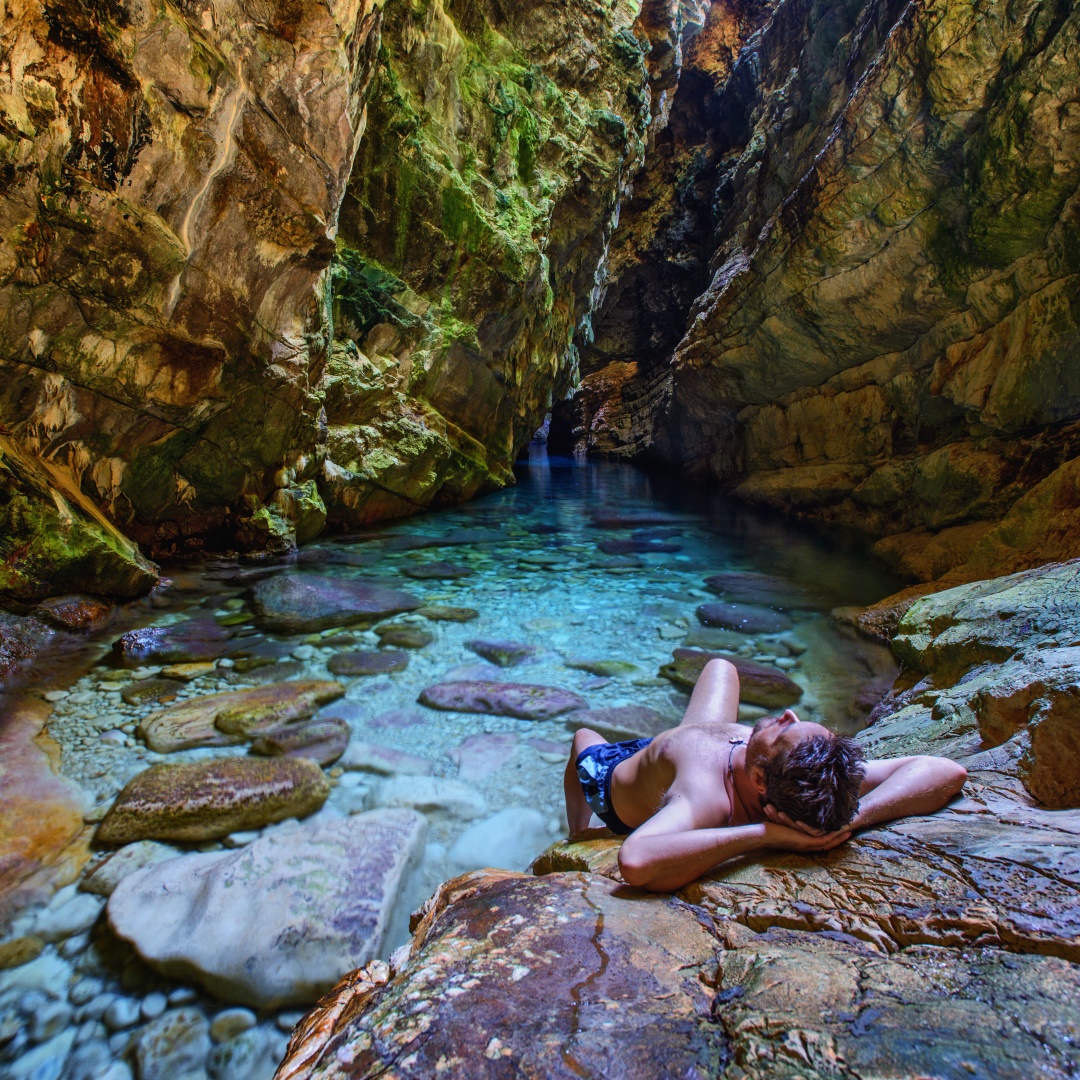 man laying in a sea cave