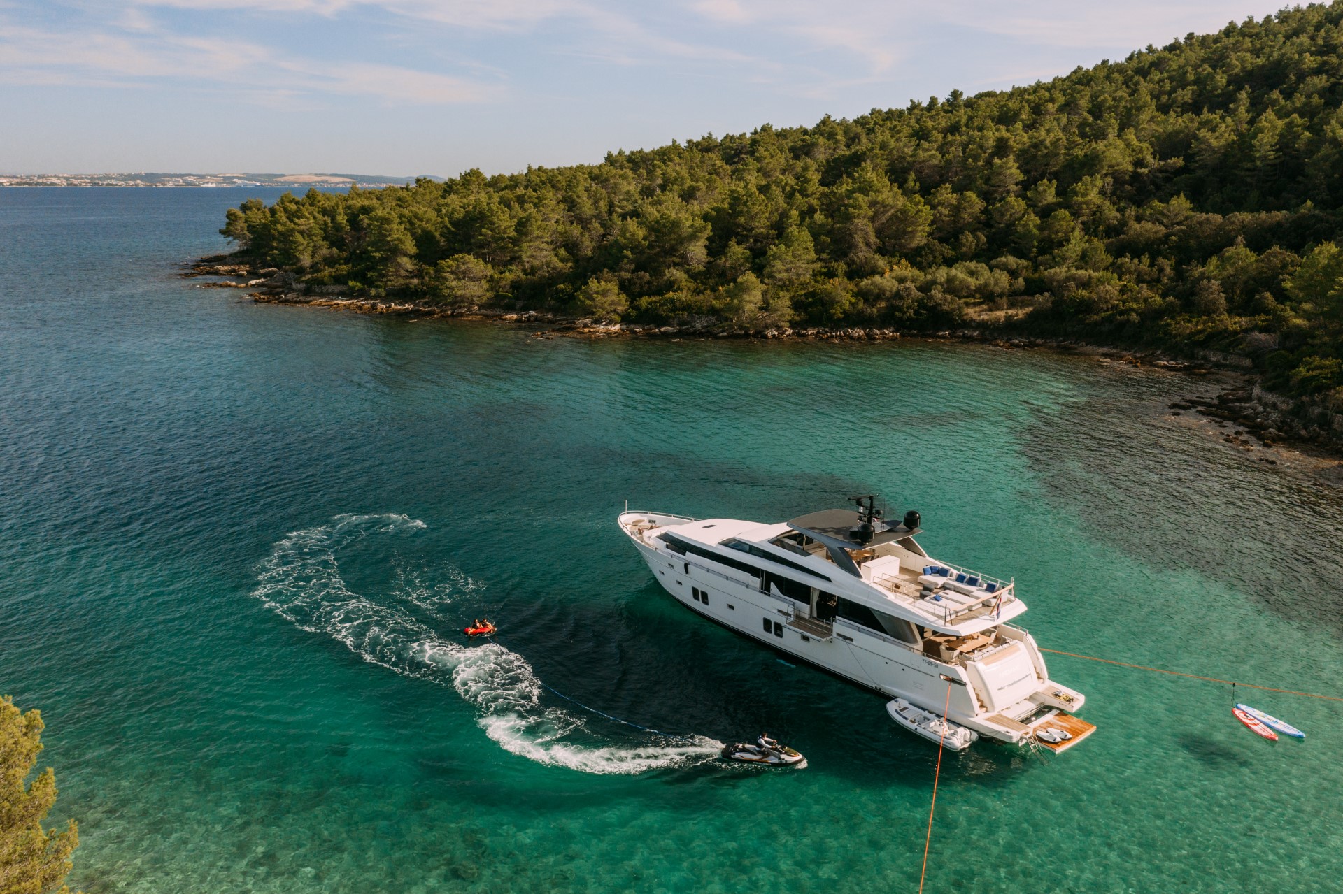 tender towing a inflatable donut around the yacht