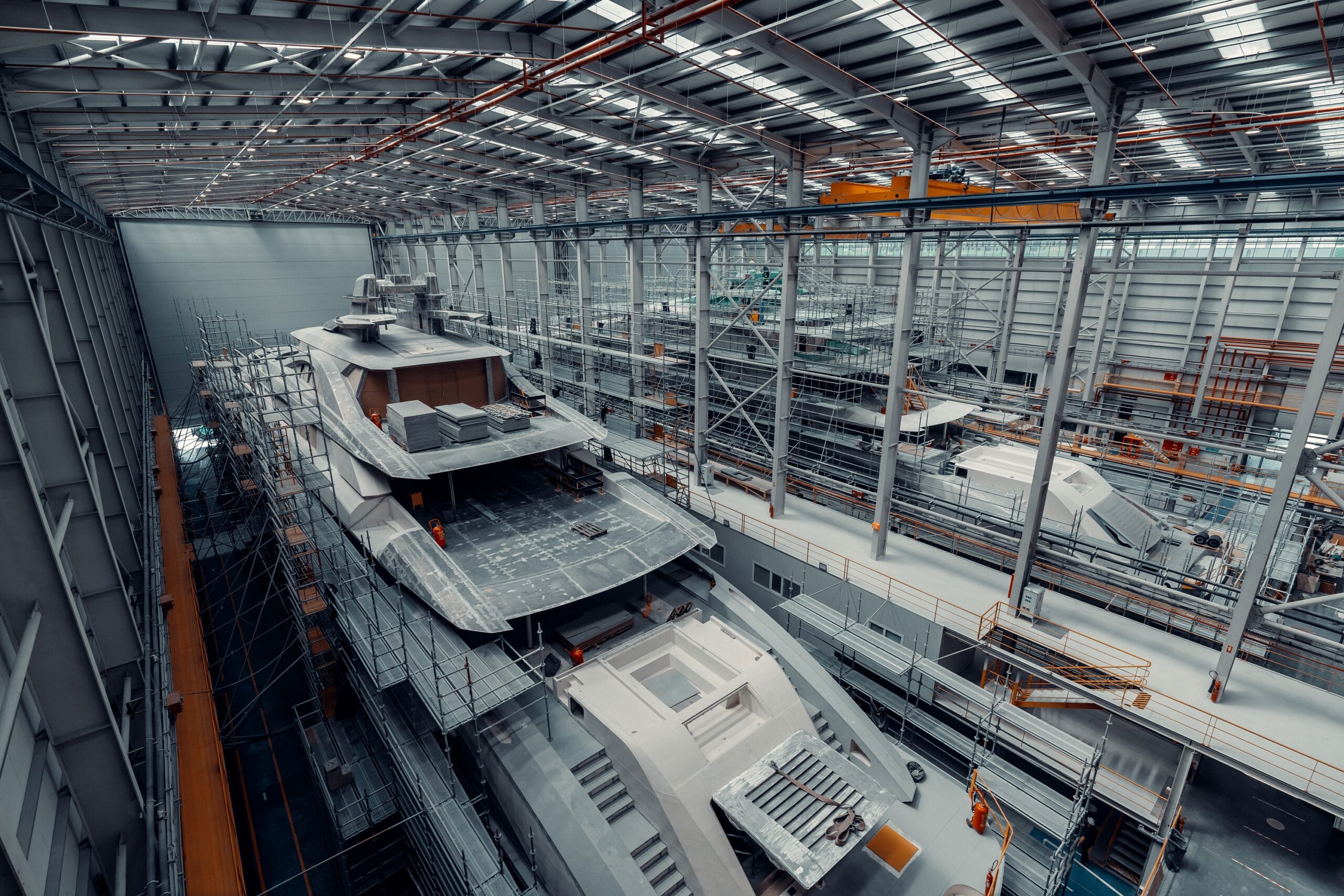 Two yachts being built in a closed hangar