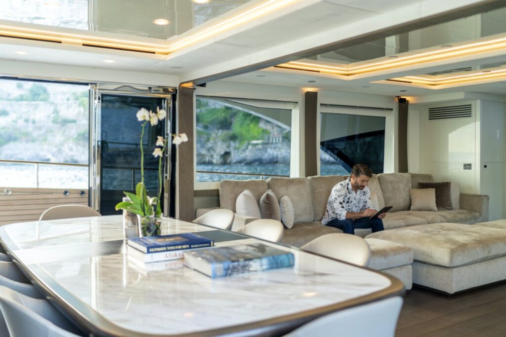 guest sitting on the salon sofa onboard vivaldi yacht charter