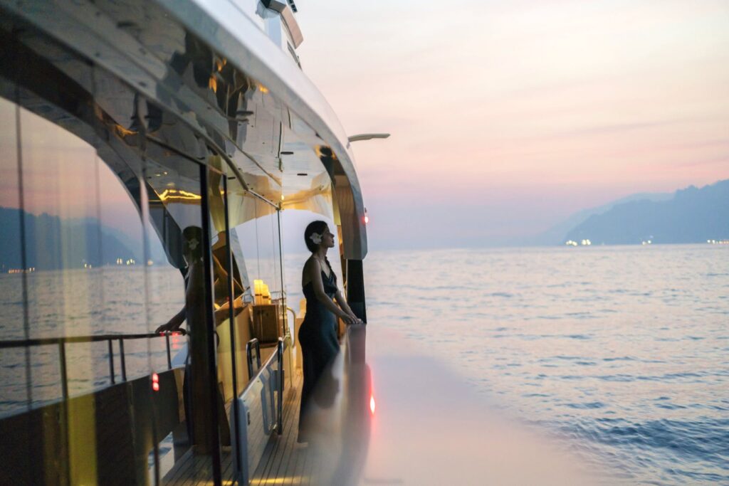 lady watching a sunset from the yacht side deck