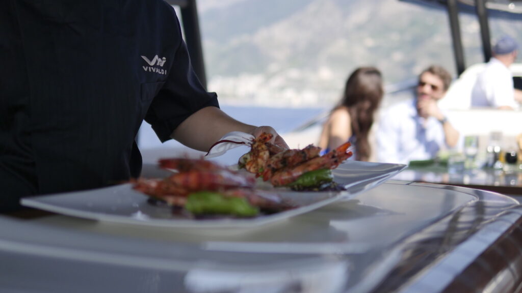 chef serving seafood on the vivaldi yacht sundeck