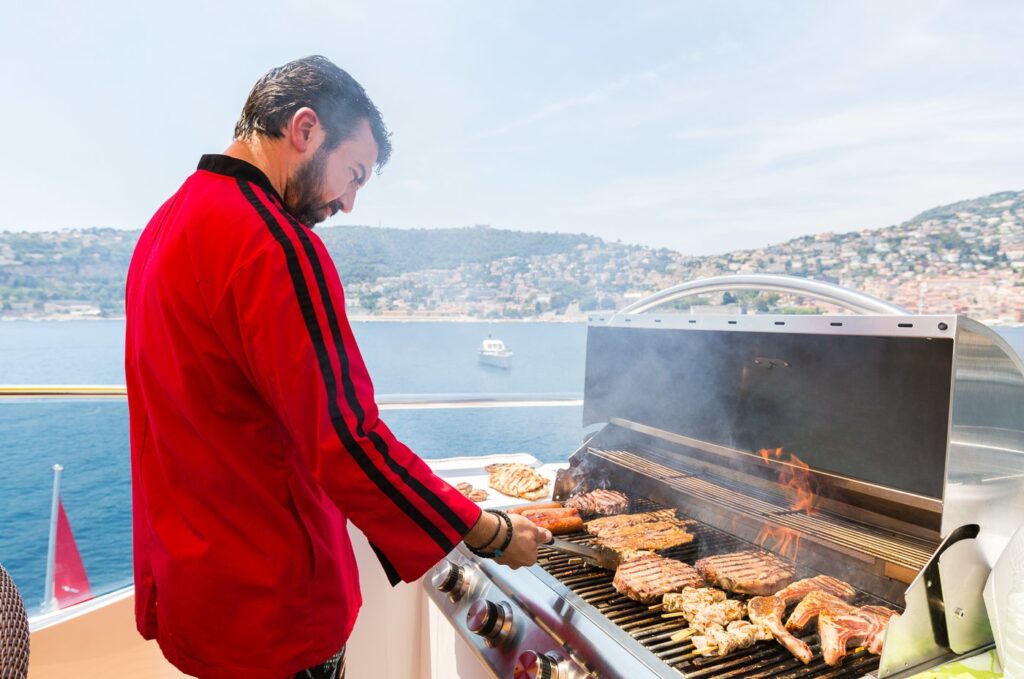 private chef grilling meat on a yacht bbq