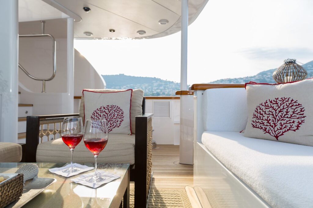 two glasses of wine on a desk onboard a yacht aft deck