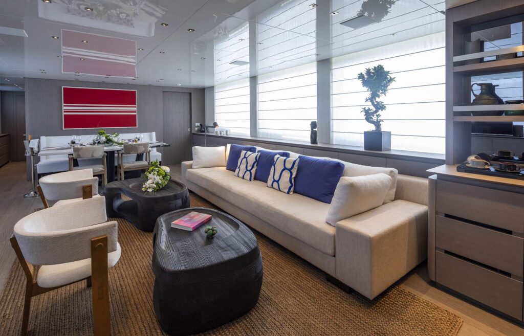 large sofa, two wooden coffee tables & sofa chairs in the yacht salon