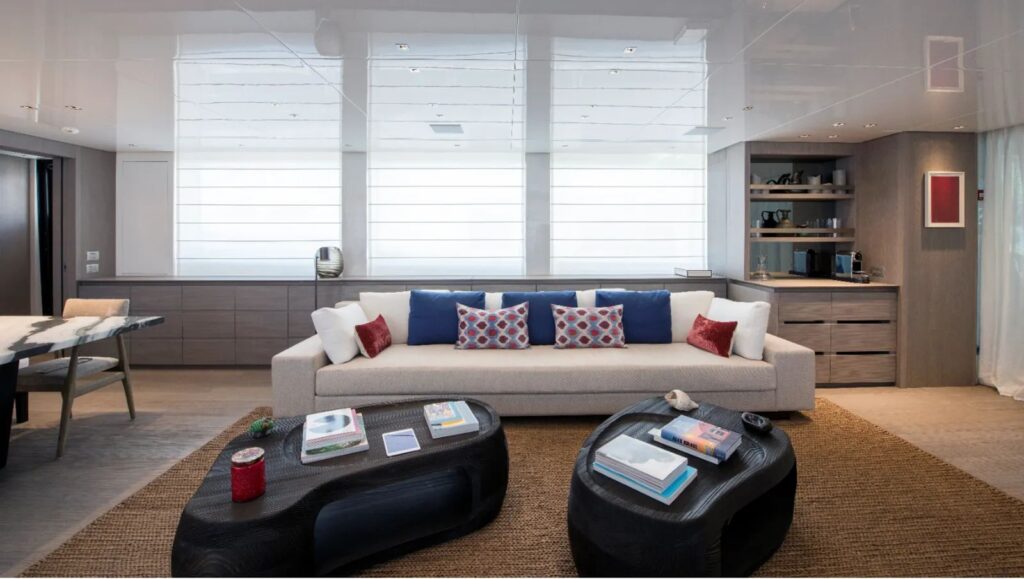 sofa on the starboard side, wooden coffee tables & wide windows in the salon