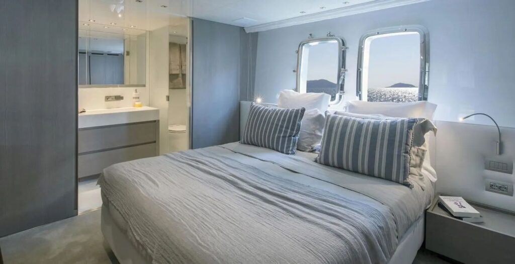 vip cabin with a queen size bed & 2 porthole windows above bed