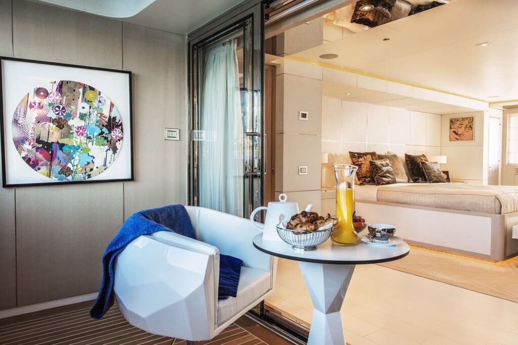 coffee table & a chair in a yacht master suite with served croissants & orange juice