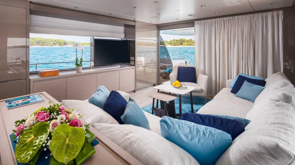 yacht main salon with a large sofa & a tv