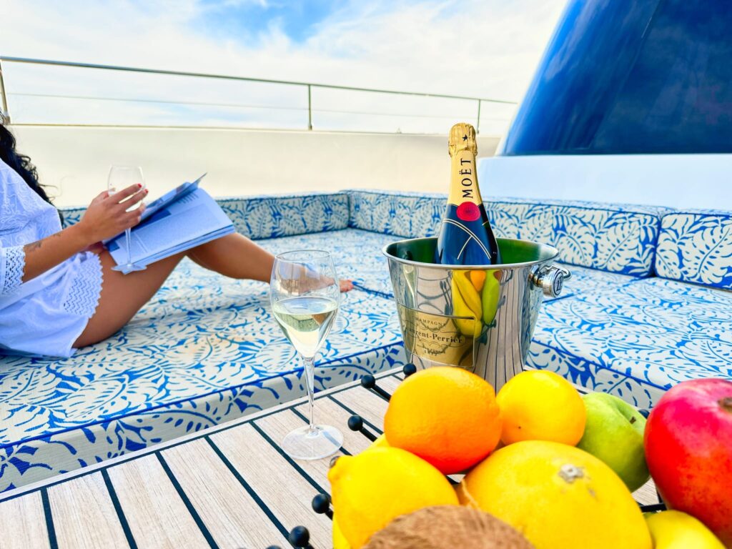 guest relaxing with a glass of champagne on a yacht sunbed